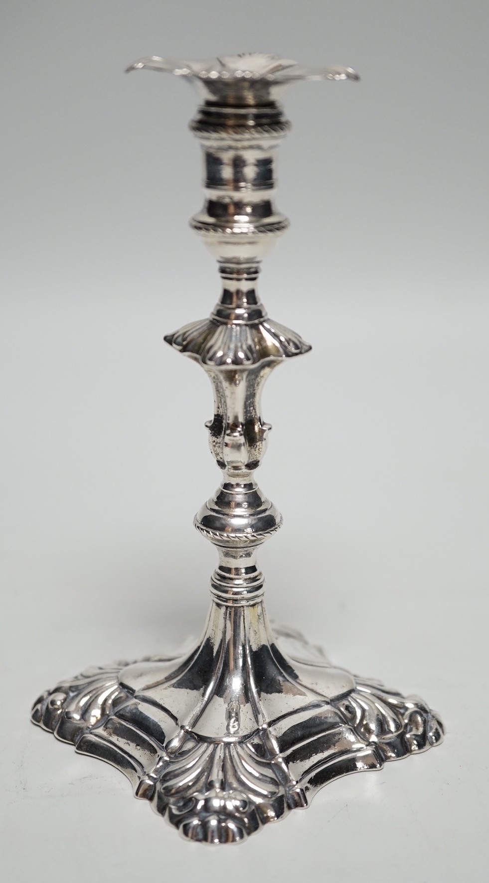 A George III cast silver taper stick, with turned knopped stem and engraved crest, maker, JH, London, 1764, 13.3cm, 4.7oz